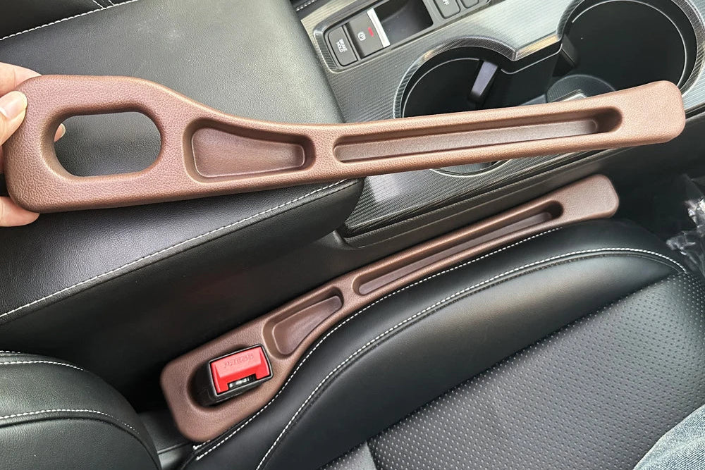 Car interior with a hand holding a brown car handle cover.